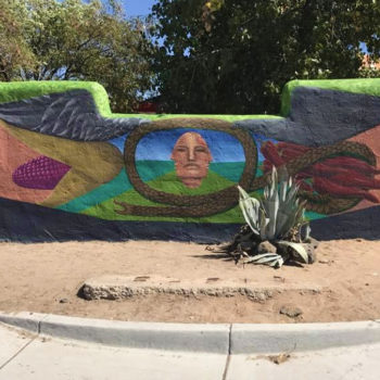 Mural on freestanding wall of a face and birdsongs coming from the frame.