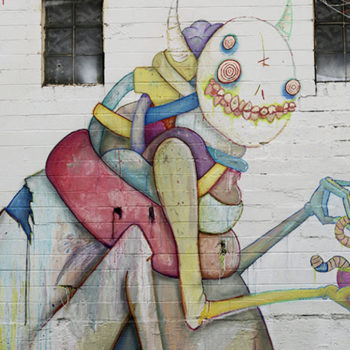 Creepy but cute creature painted on the side of a wall as a mural. Looks like it lives in a fabric store.