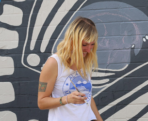 Photo of the happy young female artist with a paintbrush in hand.