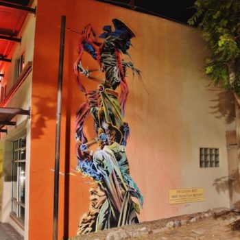 Tall mural of a futurist totom-pole of high-tech superhero capes