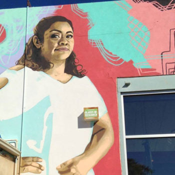 A large mural of a powerful looking confident woman.