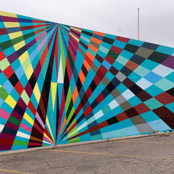 man painting mural of overlapping rays