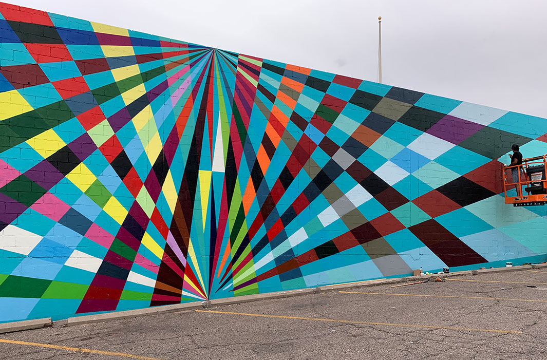 man painting mural of overlapping rays