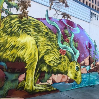 Large green jackalope drinking water