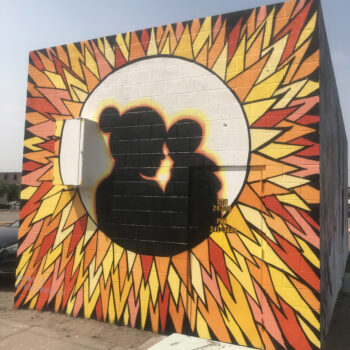 Silhouette of mother and child inside a sunburst