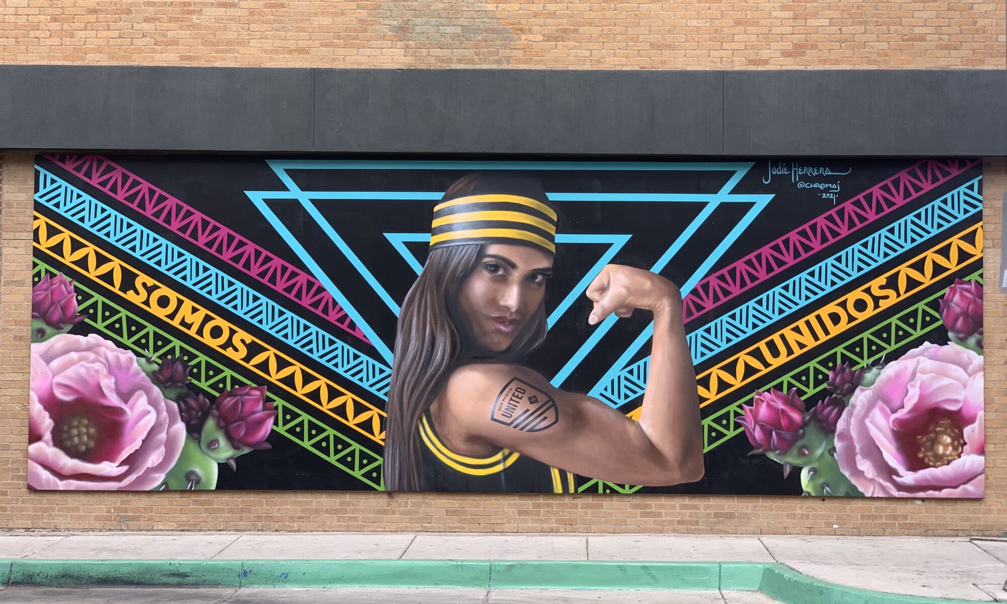 Woman Wearing NM United Attire Flexing Arm