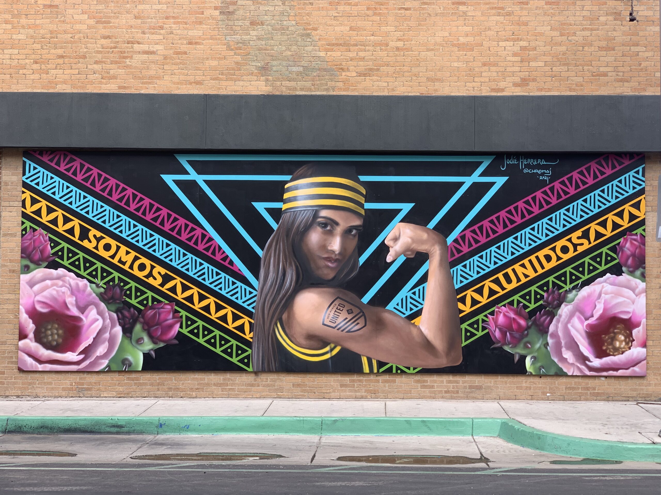 Woman Wearing NM United Attire Flexing Arm